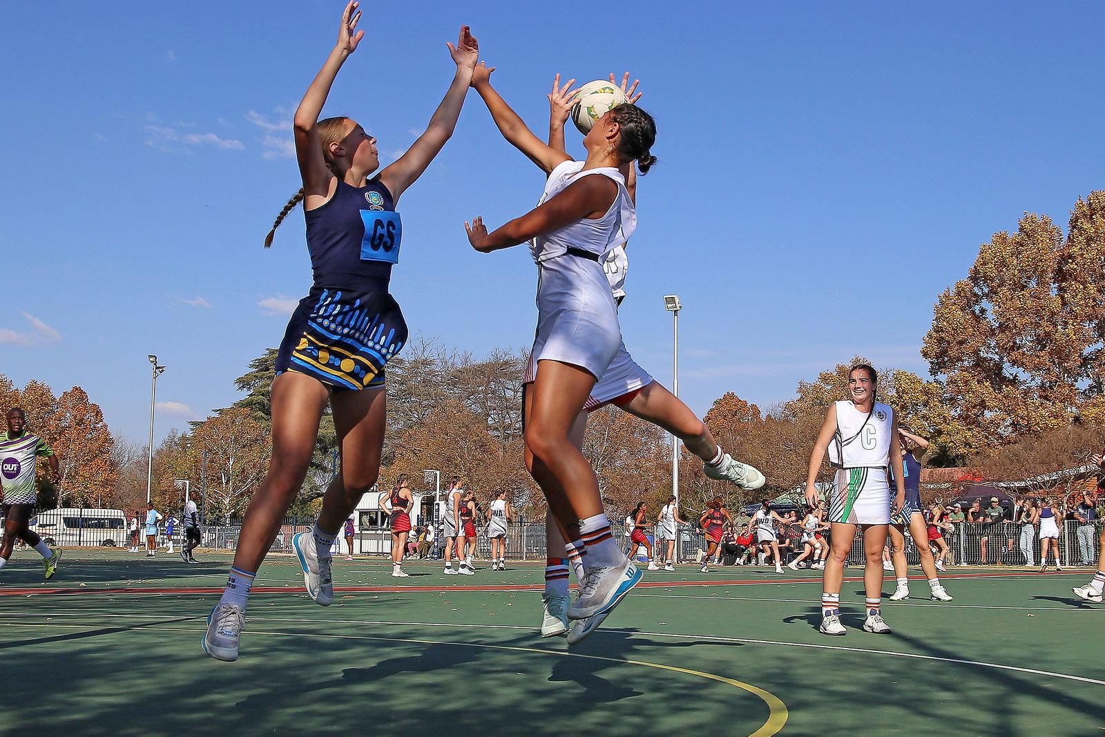 Netball players contesting a pass during an outdoor match